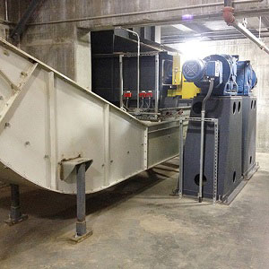 The En-Masse Drag Chain Conveyor receives biomass material directly from the in-feed hopper. The sealed drag chain carries material up to the storage silo.